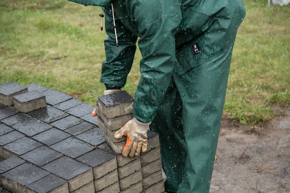 A worker laying paving stones